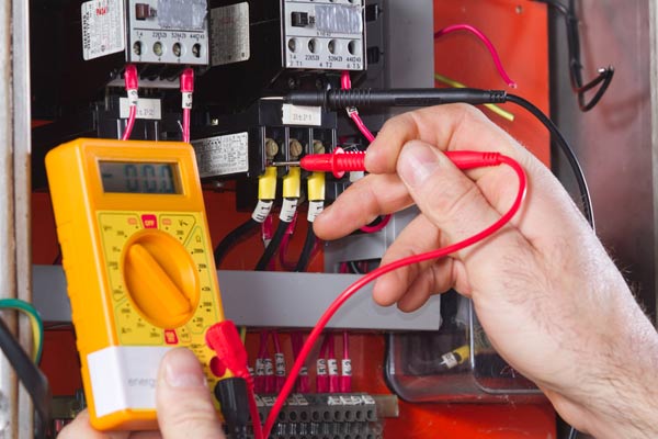 commercial electrician using voltmeter